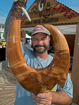 Marine life artist David Wirth displays a wooden carving of one of his authentic circle hooks, which are considered to carry the spirit of the one who carved it and the spirit of what it is made from. Image: Andy Newman